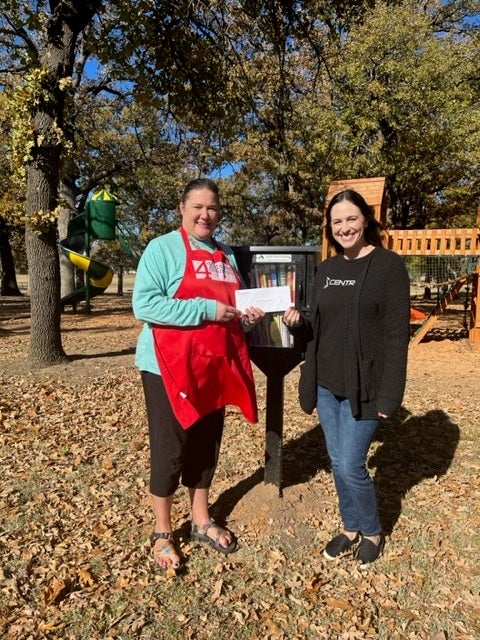 4 Kids and Community Director, Amy Petermann accepts a Central Community Foundation grant from foundation coordinator Erin Talley. 