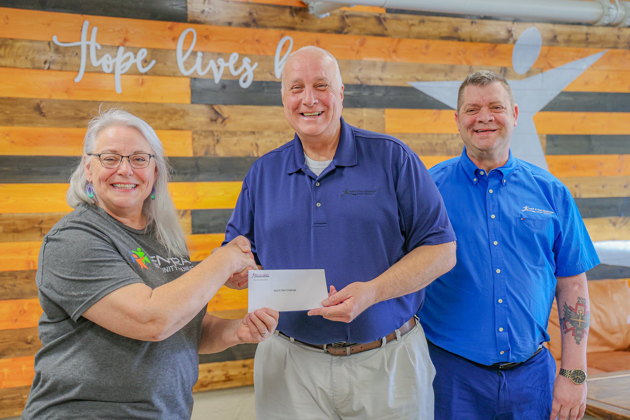 Central Community Foundation board member Donna Dollins provides Adult & Teen Challenge Executive Director, Todd Adams; and Intake Coordinator, Jason Freid, with a grant from the foundation.  
