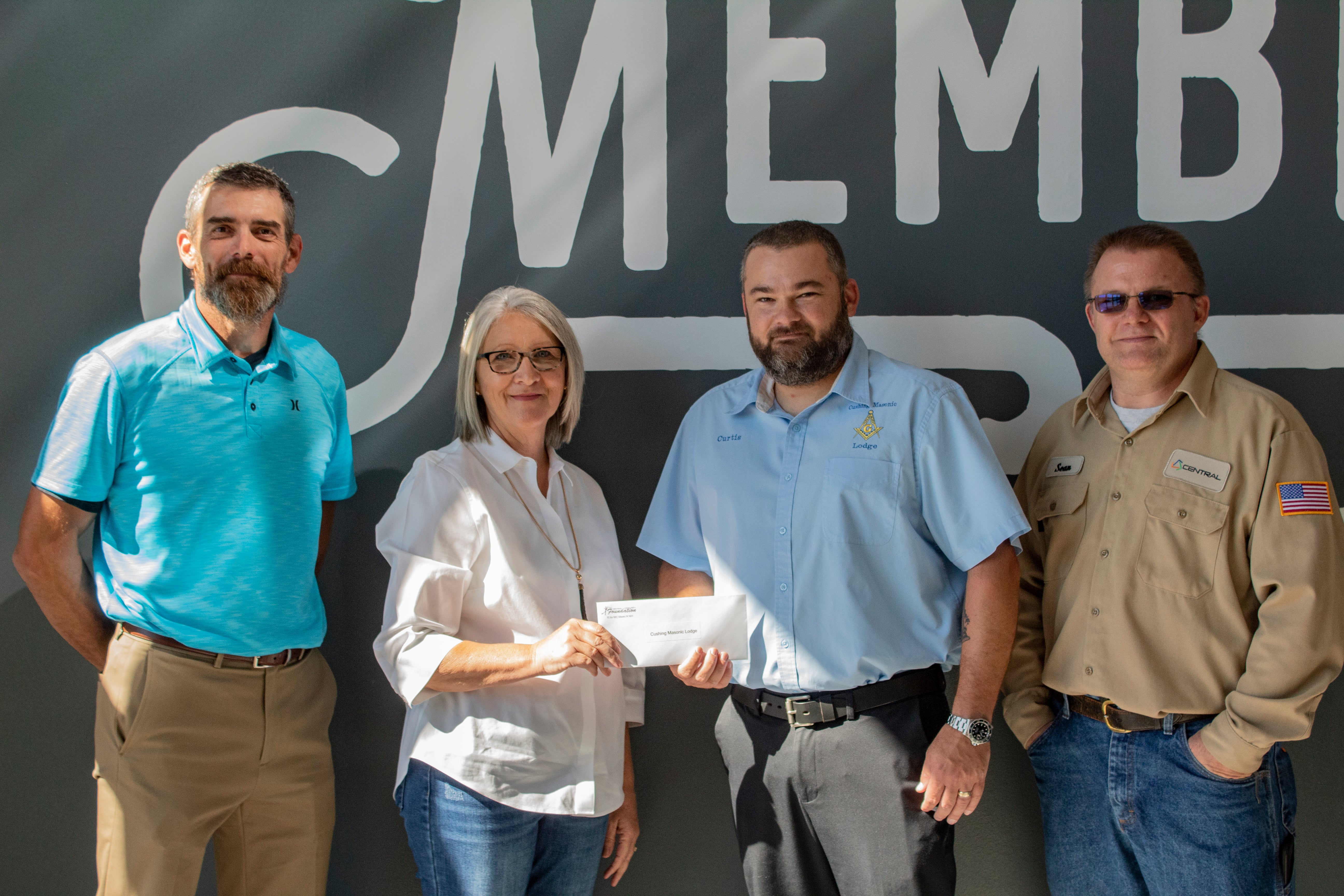 Central District 6 Trustee James Well and Central Community Foundation Board Member Gail Cookerly present a grant to Cushing Masonic Lodge members Curtis Meloy and Sean Martin.