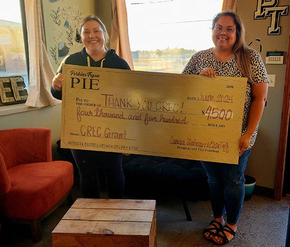 Sarah Axtell (left), PT Partners second vice president, and Sarah Wyatt (right), PT Partners secretary pose thanking the Central Community Foundation. 