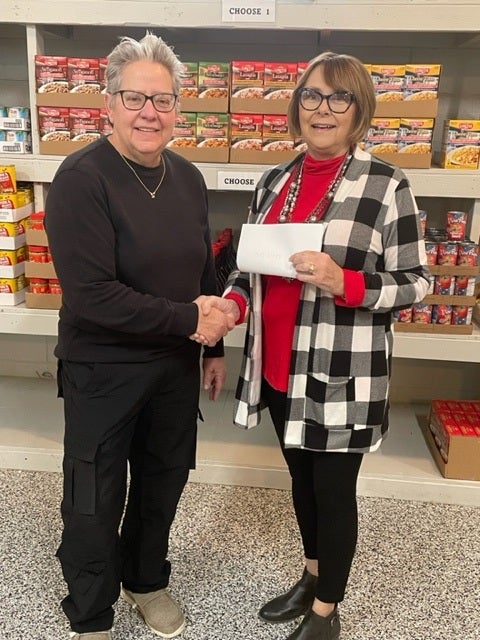 Foundation board member Janie Carey presents Mary Coffin from God’s Food Bank with Central Community Foundation grant.