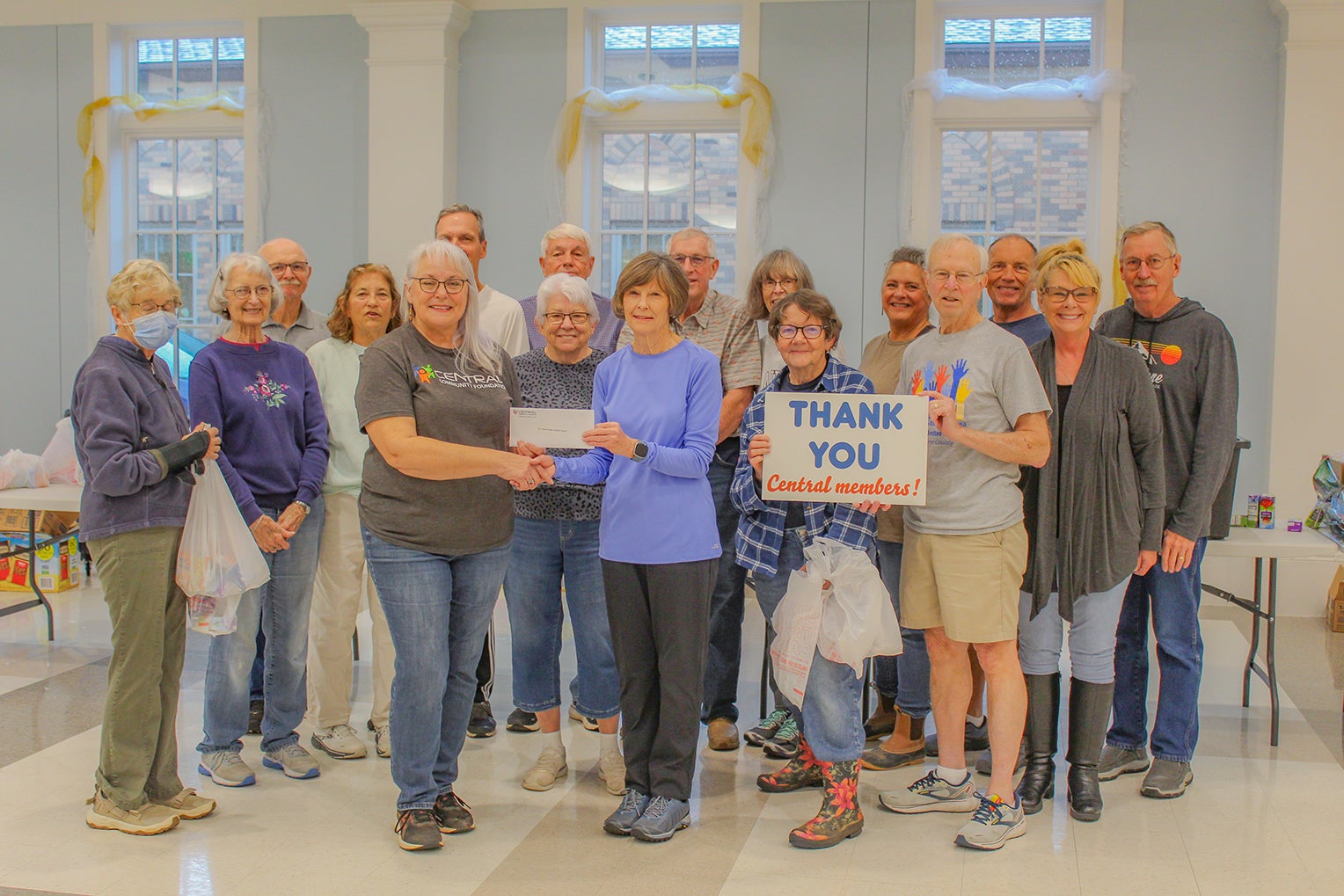 Central Community Foundation board president, Donna Dollins, presents a grant to St. Francis Xavier Catholic Church backpack ministry volunteers (not in order) Anne Marie Mahoney, Mark Mahoney, Carol Ann Powell, Cheryl Palladino, Clem Ward, Mimi Ward, David Fairbanks, Grace Wettemann, Bob Wettemann, Joe Waggoner, Pam Biggs, Paul Govek, Sabine Lewis, Scott Jones, Jean Richtmeier and Darlene Waggoner.