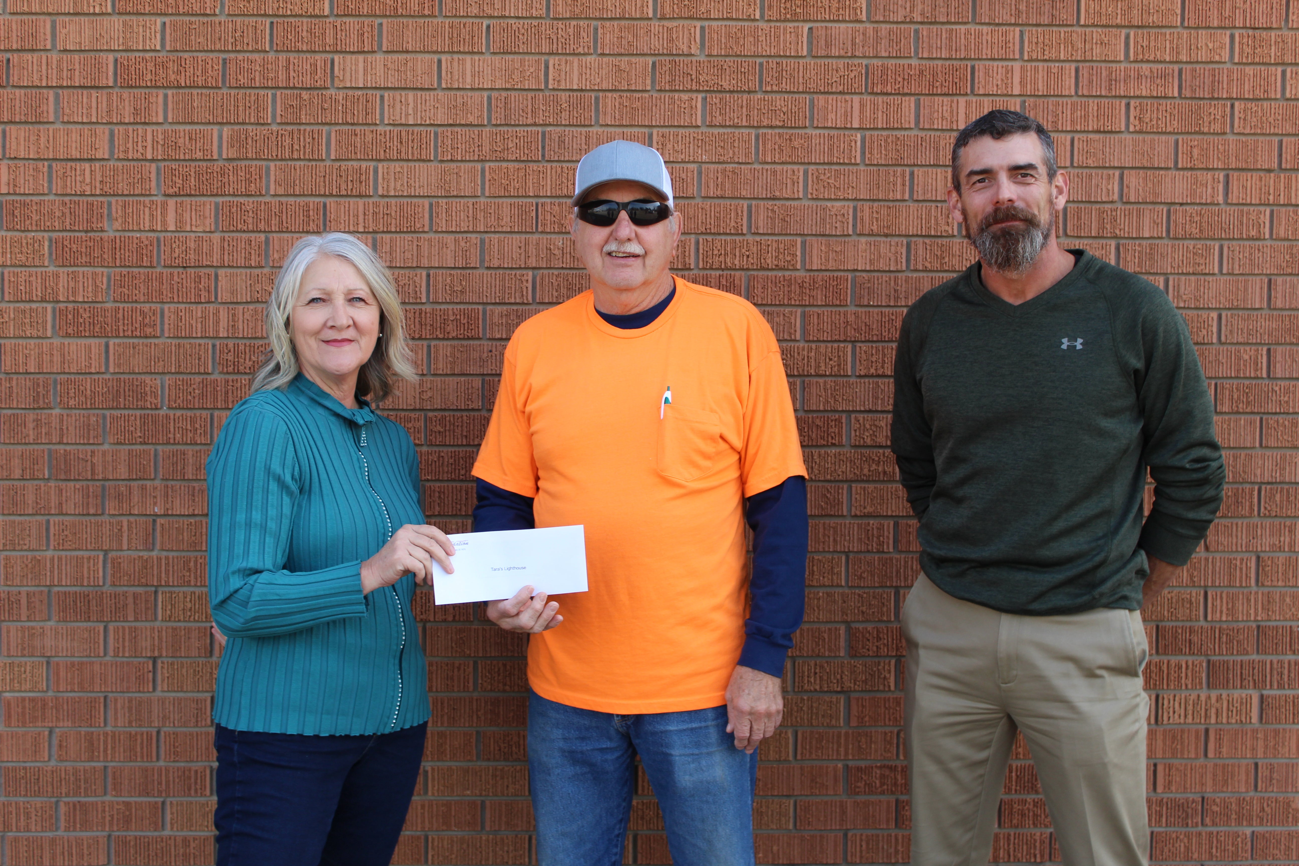 Central District 6 Trustee James Well (right) and Central Community Foundation Board Member Gail Cookerly (left) present a grant to Tara’s Lighthouse board member Randy Brown.