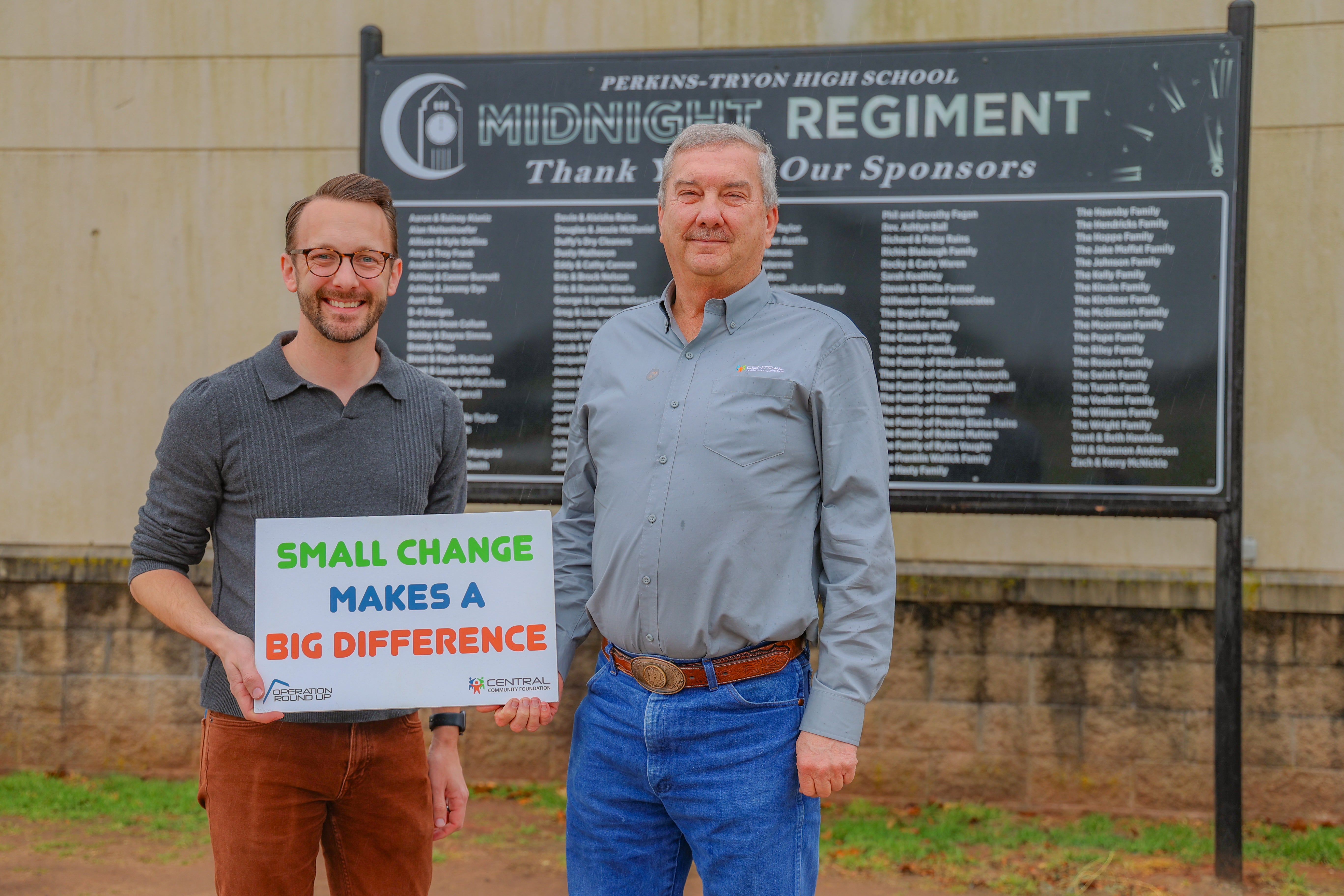 KG Robinson, director of bands for Perkins-Tryon schools, accepts a grant from Central Community Foundation board member Tracy Avers. 
